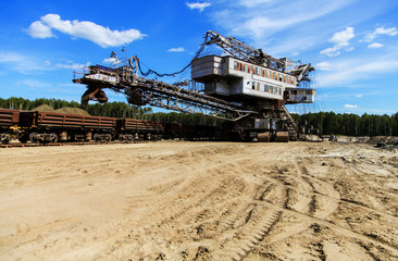 Fototapeta premium Mining machine loadind sand in train cars
