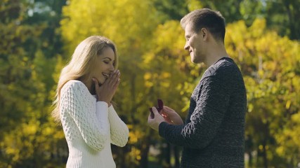 Surprise proposal in autumn park, woman said yes, excited couple, engagement