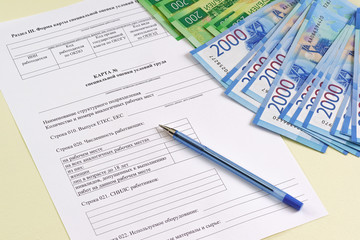 Reporting form in Russian "Map of special assessment of working conditions". Payment and summarizing the work of the special assessment Commission. Pen and money