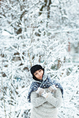 Fototapeta na wymiar Happy girl enjoys falling snow in the yard