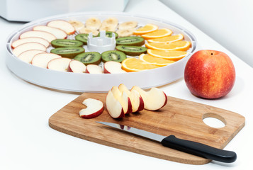 Cutting board with a knife and pieces of apples.