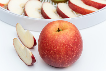 Red apple on the background of a dehydrator tray.