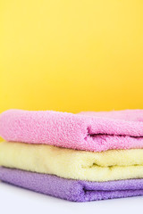 three multi-colored Terry towels have a yellow wall on white background