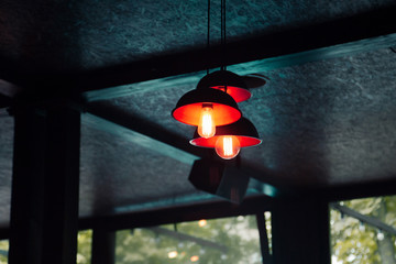 Ceiling interior of restaurant. Three red lamps hanging on the ropes