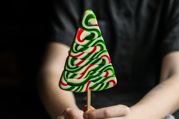 caramel on a stick in the form of a Christmas tree (candy). food background