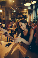 Beautiful woman looking at menu in cafe