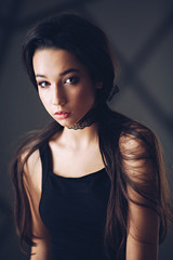 Portrait of beautiful brunette girl with makeup in fashion black clothes