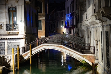 Obraz na płótnie Canvas Night view of Ponte Cappello on the Rio de Palazzo or de Canonica and Ponte del Cavalletto, Venice, Italy. Stone bridge; brick and stone structure, iron-wave balustrades.