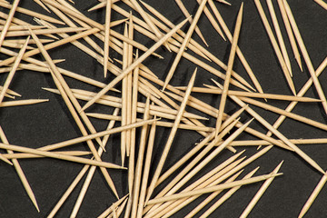 Fototapeta na wymiar Group of toothpicks on black leather pad as background