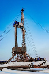Fototapeta na wymiar Drilling a deep well with a drilling rig at an oil and gas field. The deposit is located in the Far North beyond the Arctic Circle. The shooting was conducted in the winter during the polar day