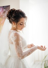 Beautiful brunette bride with stylish make-up in white dress