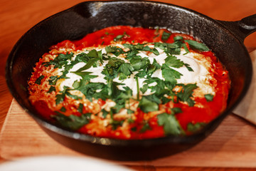 Shakshuka Served in a Frying Pan. Eggs Poached in Spicy Tomato Pepper Sauce.