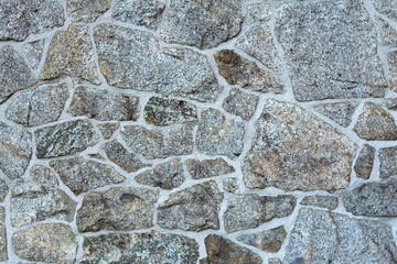 Wall with laying of natural stone of various textures.