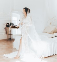 Fototapeta na wymiar Morning of fiancee.Portrait of beautiful young woman in white peignoir