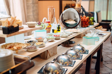 buffet in a restaurant or hotel. Metal dishes with caps.
