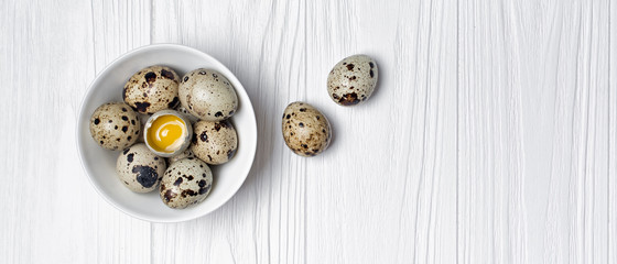 Top view on wide banner with quail eggs on white wooden background