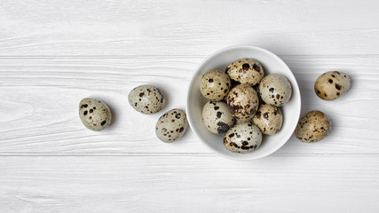 Wide banner with quail eggs on white wooden background