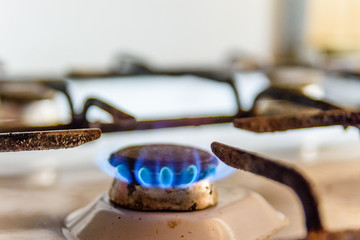 Gas burner on the white kitchen stove