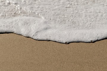 soft wave washing on to a sandy beach
