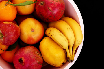 winter fruit in the fruit bowl, apples, oranges, tangerines, bananas, pomegranates, quince