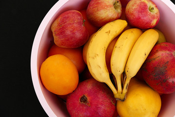 winter fruit in the fruit bowl, apples, oranges, tangerines, bananas, pomegranates, quince