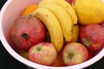 winter fruit in the fruit bowl, apples, oranges, tangerines, bananas, pomegranates, quince