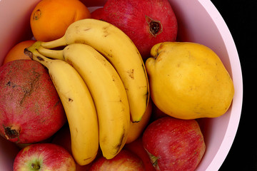 winter fruit in the fruit bowl, apples, oranges, tangerines, bananas, pomegranates, quince