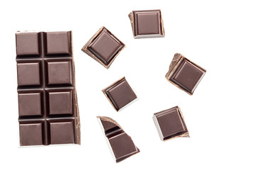 Chopped chocolate cubes, bitter, dark chocolate bar isolated on white background, top view