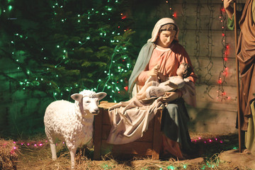 Christmas Manger scene with figures including Jesus, Mary, Joseph, sheep and magi. Soft focus