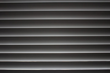 Horizontal stripes with the grey gradient of the closed jalousies..