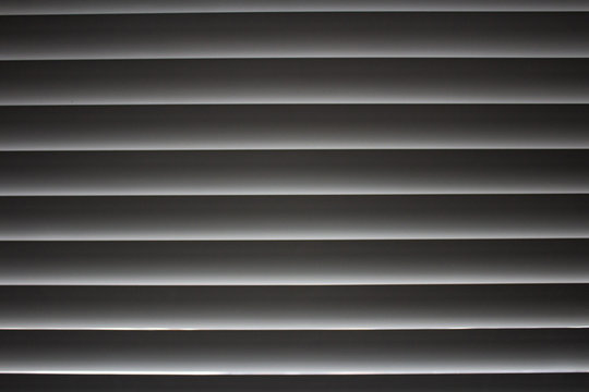 Horizontal stripes with the grey gradient of the closed jalousies..