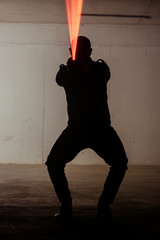 Silhouette holding pistol with laser