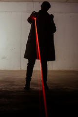 Figure of a assassin man standing still while holding laser revolver