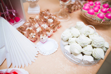 Delicious and tasty dessert table with cupcakes and shots at reception closeup
