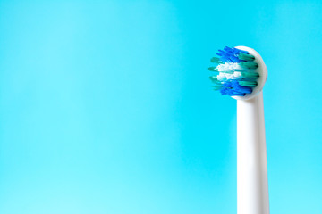 Electric toothbrush closeup on a blue background