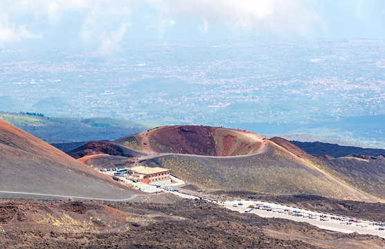 Crater Silvestri Inferiori (1886m) on Mount Etna, Etna national park, Sicily, Italy. Rifugio Sapienza - tourists parking and base station on the foothills of Mount Etna on the foreground