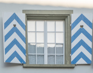 Typical german window with open colorful  shutters 