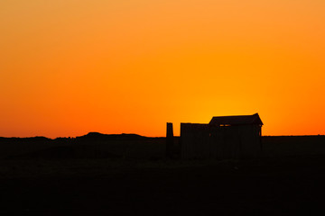 Obraz premium Abandoned Australian shed with sunset background