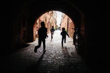 Silhouette of boys running through a tunnel in Marrakech, Morocco