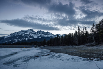 Lake Minnewanka Banff, Canada. Sunset over the forest in the midst of winter. 