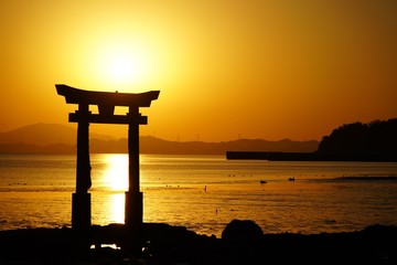 沈む夕日と海の中の鳥居