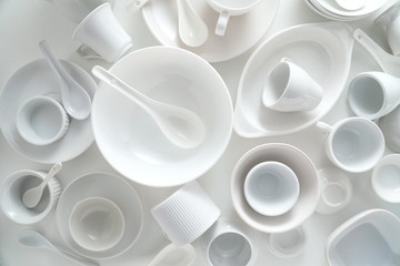 White ceramic tableware set on white background top view
