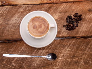 tasse de café avec cuillère, déposé sur une planche de bois