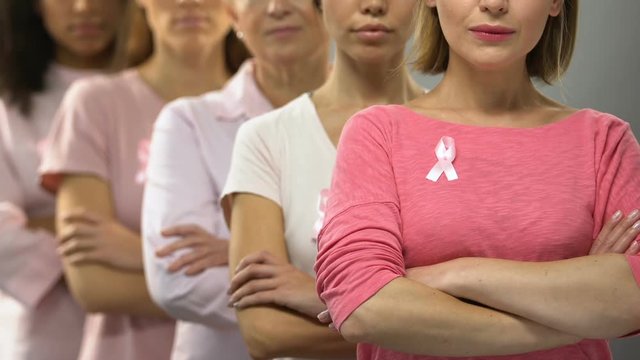 Group of ladies with pink ribbons recommending timely diagnosis of breast cancer