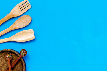 Village wooden cutlery set on blue background top view mock-up