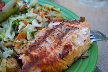 grilled salmon steak with vegetables on plate closeup