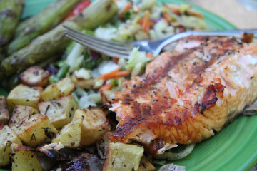 grilled salmon steak with vegetables and asparagus closeup on plate