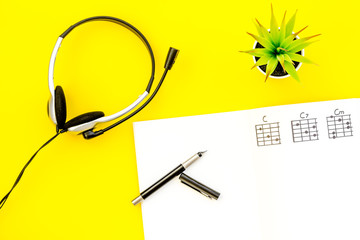 songwriter or dj work place with notes and headphones on yellow background top view