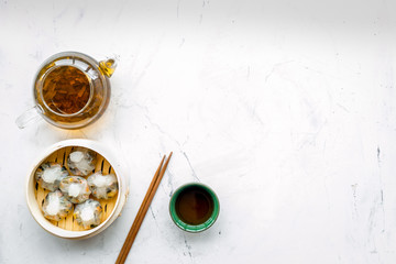 Dinner in Chinese restaurant with dim sum, sticks and herbal tea on marble background top view space for text