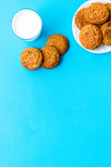 Children tradition evening dessert. Milk and homemade cookies on blue background top view copy space